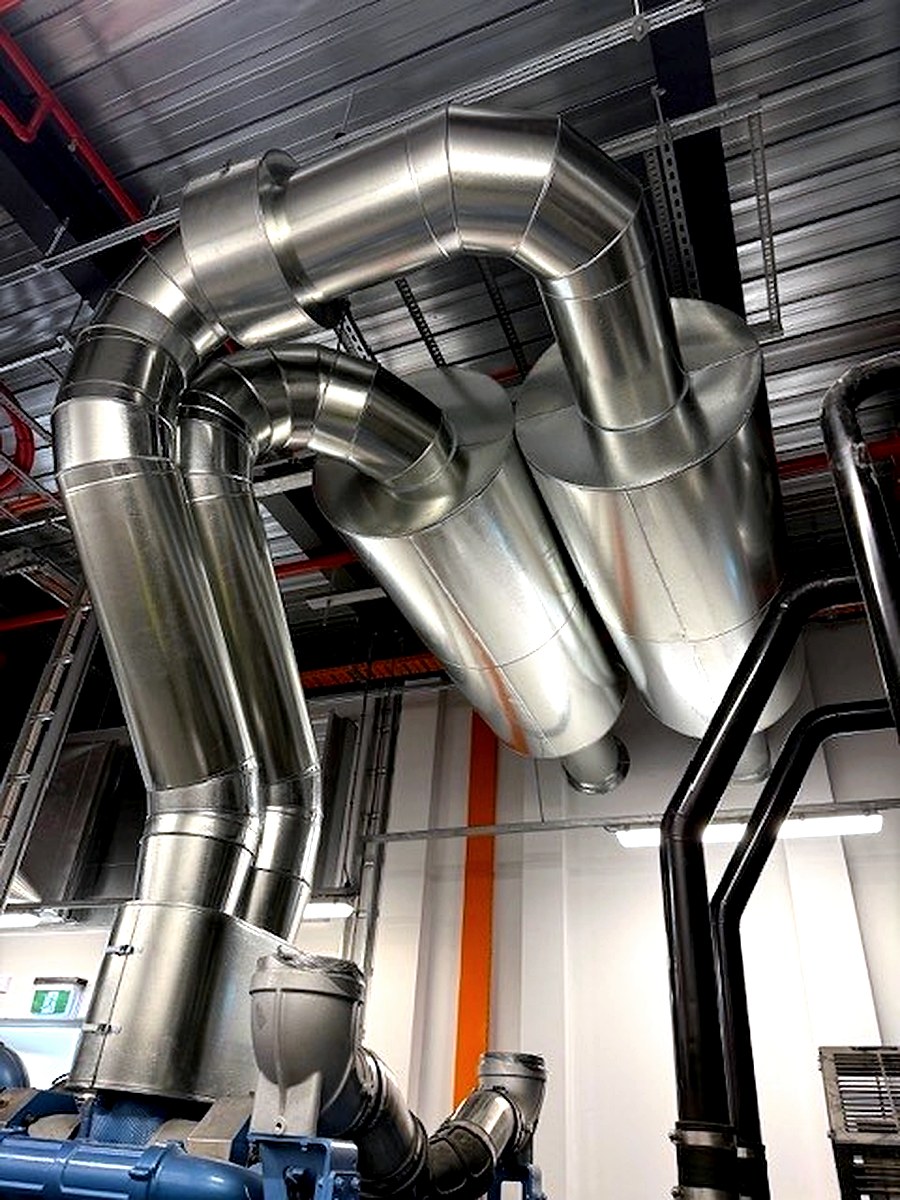 Sheet metal cladding on complex overhead insulated pipe bends in an industrial facility